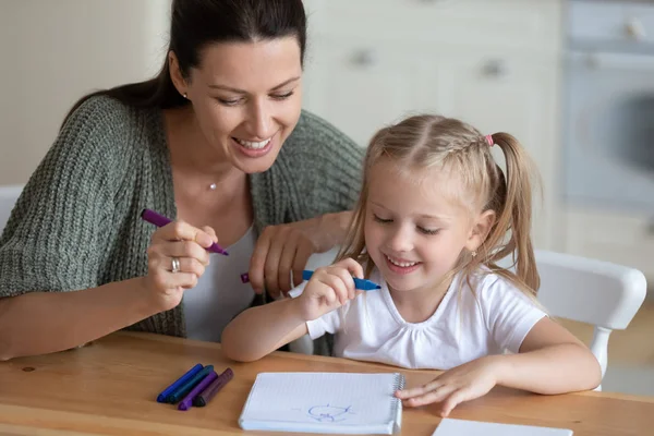Мать и дочь рисуют ручками из войлока в помещении — стоковое фото