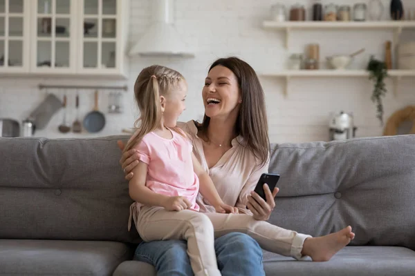 Vrolijke dochter zittend op Mother lap geniet van online onderwijsprogramma's — Stockfoto