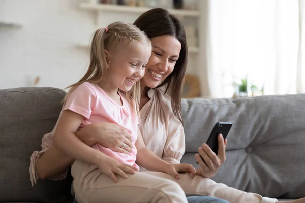 Madre e hija usando teléfono inteligente que se divierten en línea — Foto de Stock