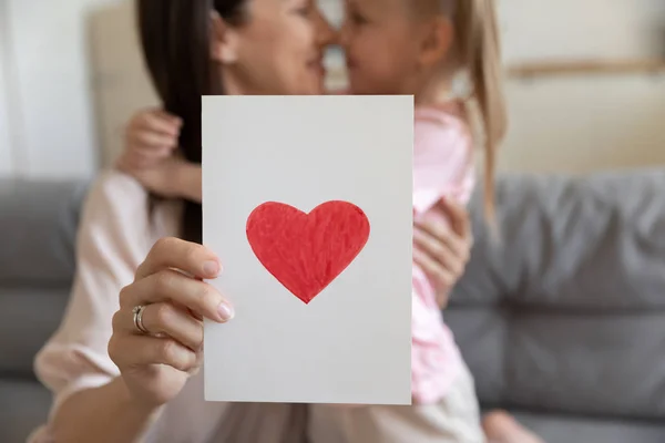 Cartão postal close-up com coração vermelho atraído segurando mãe abraça filha — Fotografia de Stock