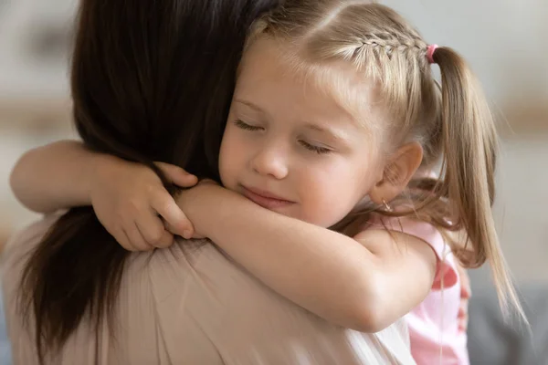 Close-up uitzicht schattig dochter gesloten ogen omarmt liefdevolle moeder — Stockfoto