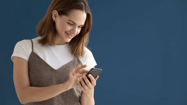 Lachende mooie vrouw met behulp van mobiele telefoon apps geïsoleerd — Stockfoto