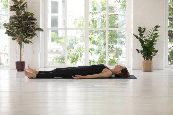 Mujer joven haciendo ejercicio Savasana, Cadáver, Cadáver, practicando yoga —  Fotos de Stock