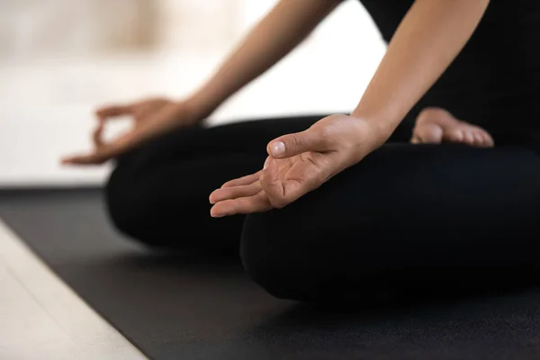 Frau sitzt in Lotus-Pose aus nächster Nähe, praktiziert Yoga, Padmasana-Übung — Stockfoto