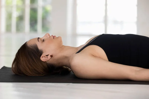 Young woman with closed eyes practicing yoga, Savasana, Corpse pose — Stock Photo, Image