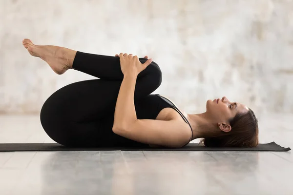 Beautiful woman practicing yoga, Knees to Chest pose, Apanasana exercise — Stock Photo, Image