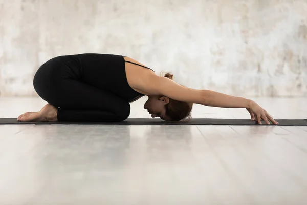 Bella donna che pratica yoga, rilassante in posa bambino, esercizio Balasana — Foto Stock