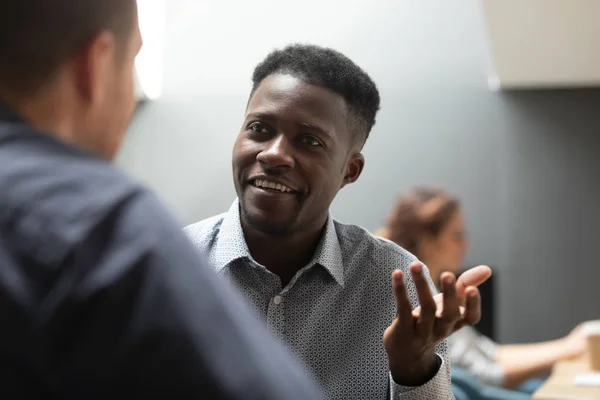 Empresário africano profissional conversando com colega caucasiano masculino no cargo — Fotografia de Stock