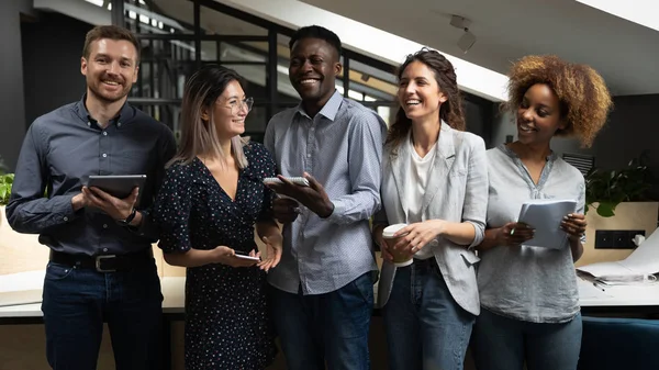 Alegre equipe de negócios multicultural feliz rindo de pé no escritório — Fotografia de Stock