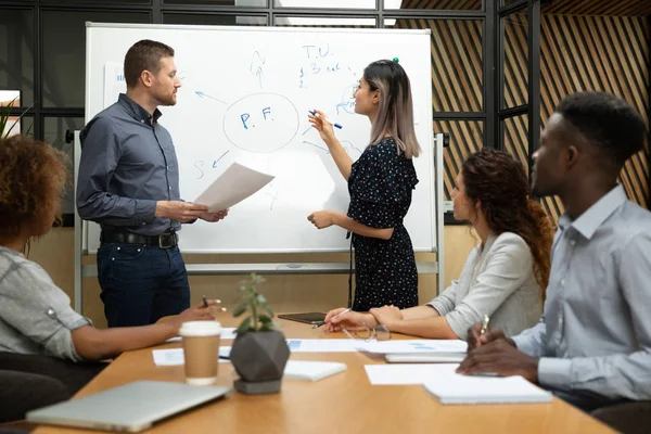 Divers asiatiques et caucasiens entraîneurs dessin sur tableau blanc au bureau — Photo