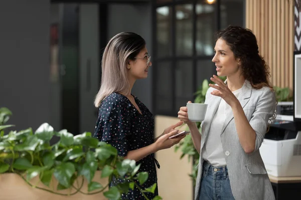 Two young diverse business women talking during work break — Stock Photo, Image