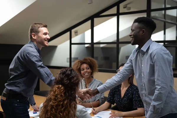 Smiling diverse business partners handshake at group office meeting — Stock Photo, Image