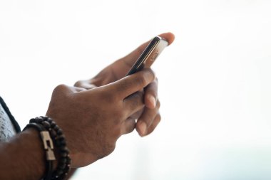 Yakın görüntü afrikalı amerikalı mans elleri akıllı telefon tutan.