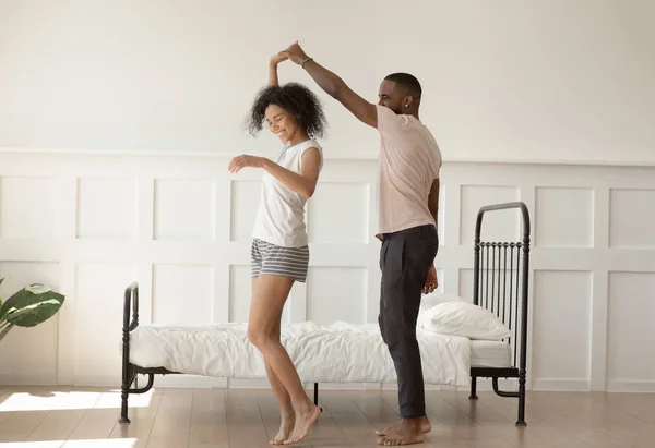 Happy barefoot african american loving family couple dancing in bedrowbed . — Stok Foto