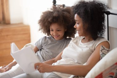 Karışık ırk kadın nasıl sevimli çocuk kız okumak için öğretim.