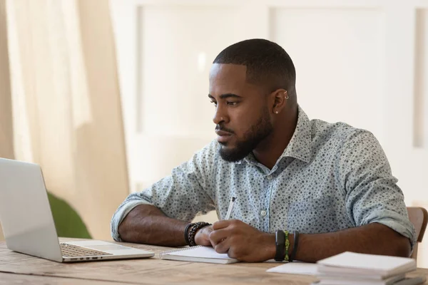 Concentrado millennial afroamericano chico centrado en cursos universitarios en línea . —  Fotos de Stock