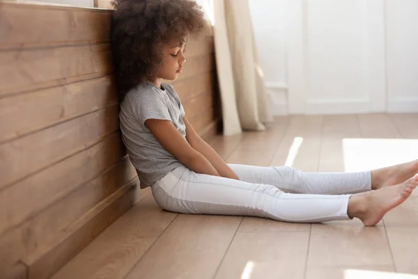 Boos zwart schattig Kid meisje zittend alleen op vloer. — Stockfoto