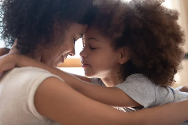 Mezcla raza madre tocando frentes con poco lindo hija . — Foto de Stock