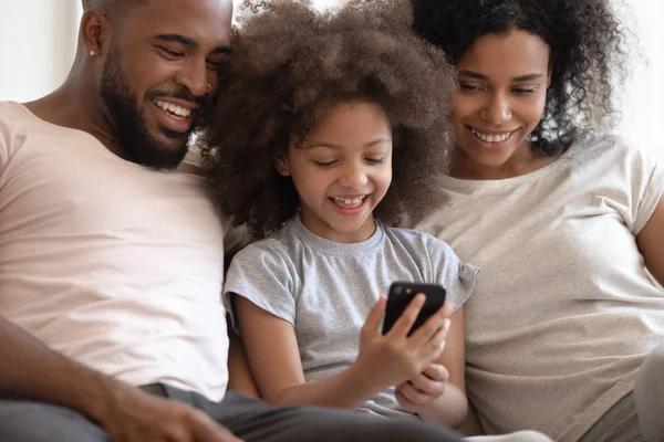 Gelukkig African American ouders kijken weinig lachende Kid spelen spel. — Stockfoto