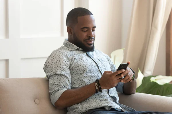 Щасливий позитивний чорний чоловік робить покупки на веб-сайтах . — стокове фото