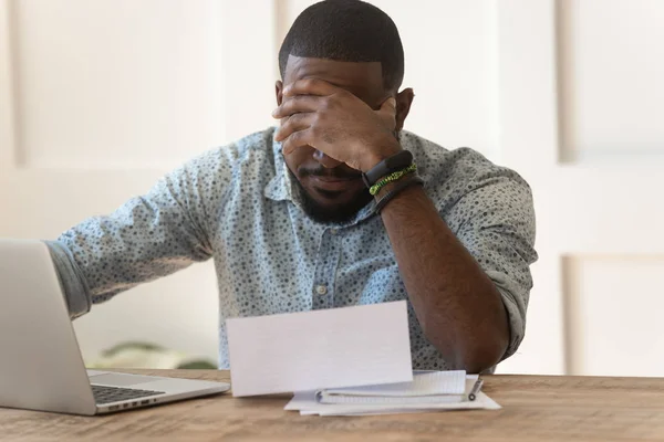 Stressed upset african american reading bad news in letter. — Stock Photo, Image