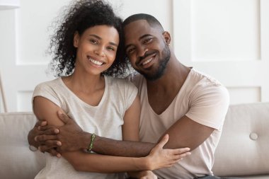 Mutlu genç gülümseyen sarılma afrikalı-amerikalı aile portresi.