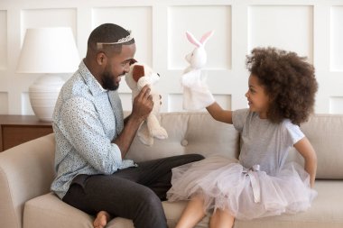 Mutlu afrikalı amerikalı baba küçük kızı ile prensesler gibi giyinmiş.