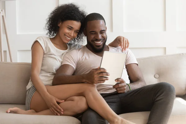 Sonriendo feliz afroamericano cónyuge de la familia usando tableta digital . —  Fotos de Stock