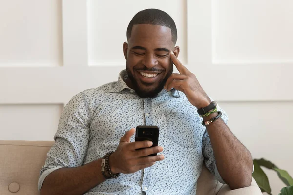 Gelukkig glimlachend jong African American Guy houden mobiele telefoon. — Stockfoto