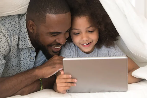 Feliz afroamericano padre utilizando tableta digital con linda hija . — Foto de Stock