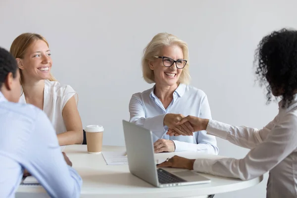 Sorridente diverse donne d'affari handshake accordo di chiusura alla riunione — Foto Stock