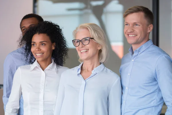 Gemotiveerde medewerkers kijken in afstand poseren voor groepsfoto — Stockfoto