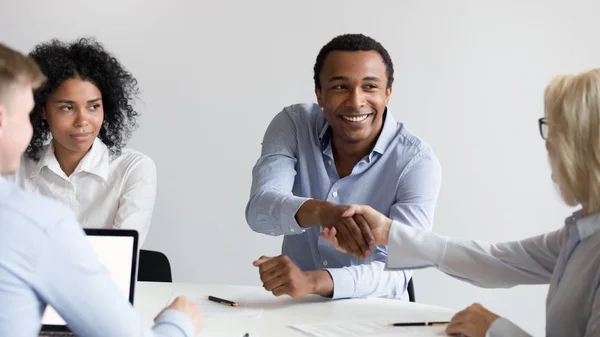 Sorrindo preto empresário aperto de mão colega no escritório briefing — Fotografia de Stock