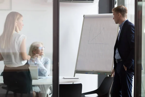 Diverse collega's onderhandelen over whiteboard presentatie tijdens briefing — Stockfoto