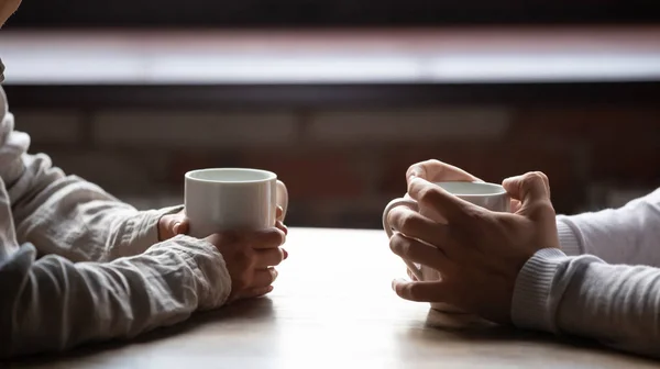 Close up mulher e homem segurando xícaras de café na mesa — Fotografia de Stock