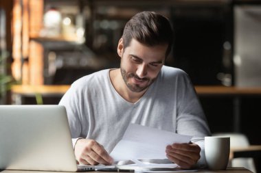 Memnun adam kafede evrak yapıyor, mektup veya yasal belge tutan