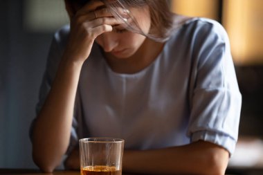 Alkol bardağı ile tek başına oturan mutsuz kadın kapatın