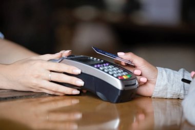 Temassız kartla ödeme yapan kadını kapatın, bar kontuacında terminal