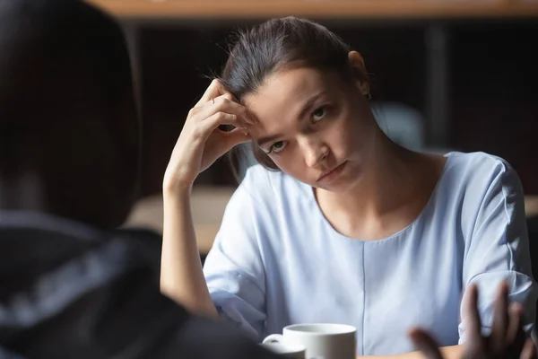 Bored unhappy girlfriend listening to African American boyfriend in cafe — Stock Photo, Image
