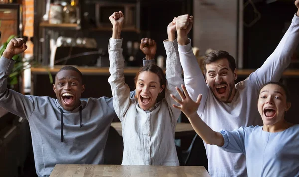 Возбужденные разнообразные друзья, футбольные болельщики празднуют победу гола в кафе — стоковое фото