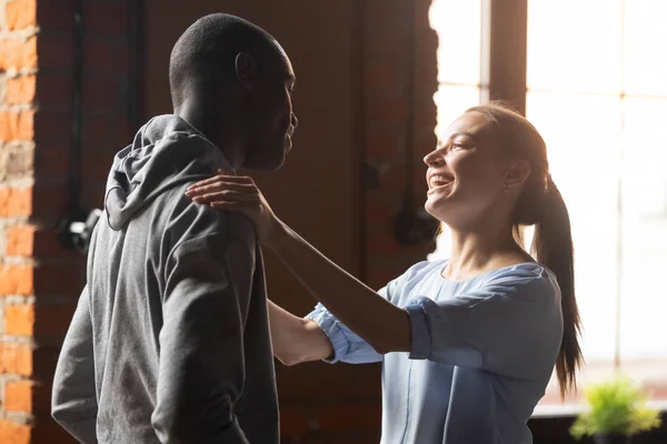 Mujer sonriente saludando hombre afroamericano en reunión repentina — Foto de Stock