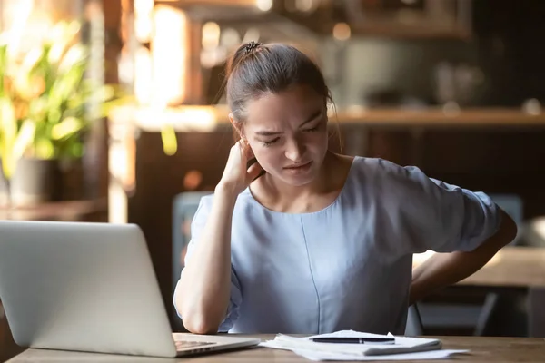 Mulher cansada sentindo dor após o trabalho sedentário do computador no café — Fotografia de Stock