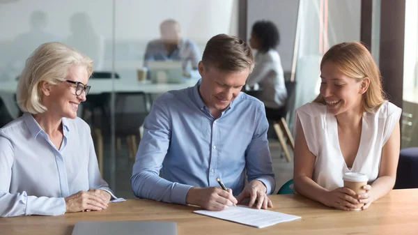 Excited young couple sign contract buying house together — Stock Photo, Image