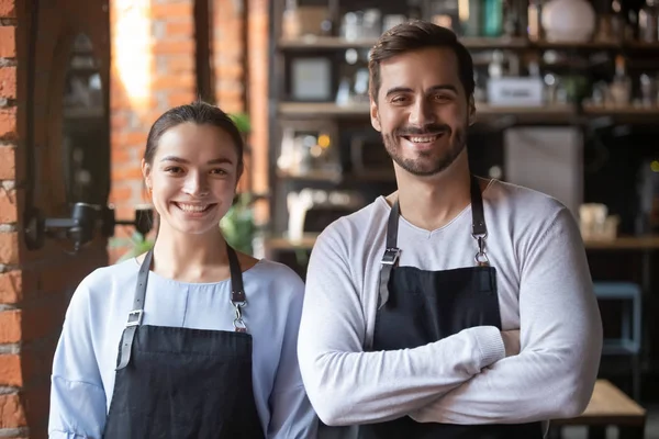 Head shot portrait of coffeehouse workers, smiling waiter and waitress