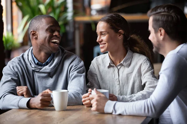 Afroamerikanska och kaukasiska vänner ha kul tillsammans i kaffehuset — Stockfoto