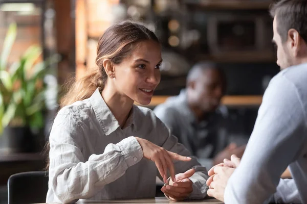 Atractiva sonriente mujer de raza mixta charlando con el hombre en el café —  Fotos de Stock