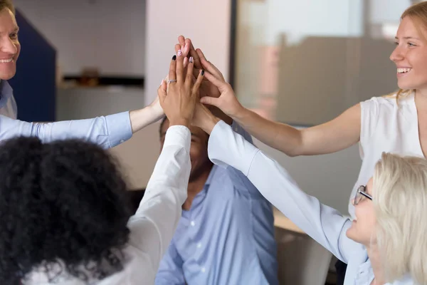 Primer plano de los empleados emocionados unen sus manos mostrando unidad — Foto de Stock