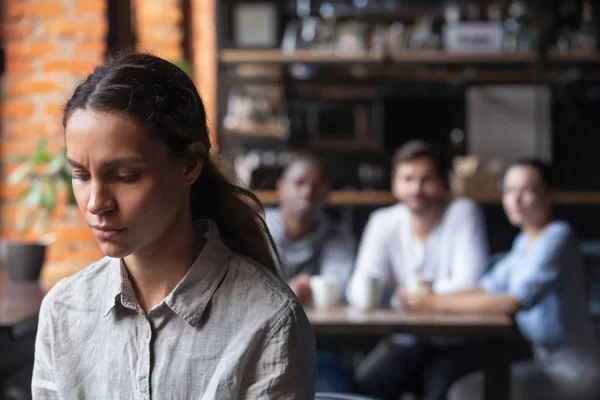 Upprörd blandad ras kvinna som lider av mobbning, sitter ensam i kaféet — Stockfoto