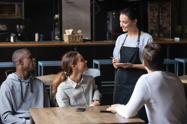 Divers amis faisant l'ordre dans le café, serveuse souriante servant les clients — Photo