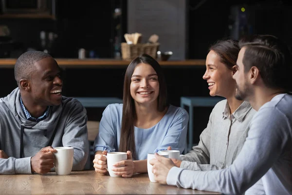 Amis afro-américains et caucasiens bavardant dans un café, buvant du café — Photo